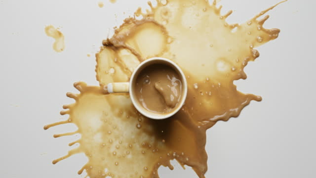 Sugar falling into coffee cup