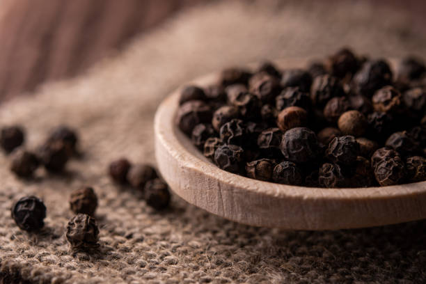 istock spoon with black pepper on jute fabric 1189175381
