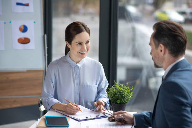 istock Smiling assistant talking to businessman and making some notes in the morning 1189175990