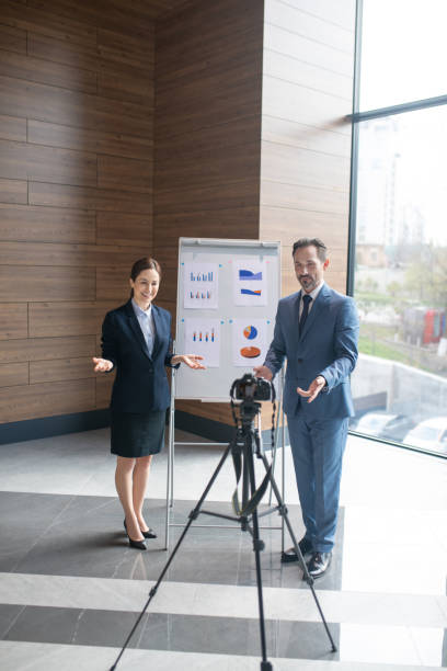 istock Couple of successful entrepreneurs filming online tutorial for young businessmen 1189176006