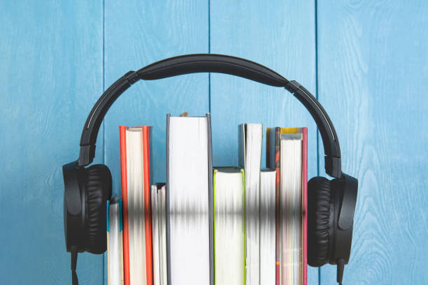 istock concept of audio book. headphone and books on blue background 1189176748