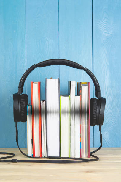 istock concept of audio book. headphone and books on blue background 1189176929