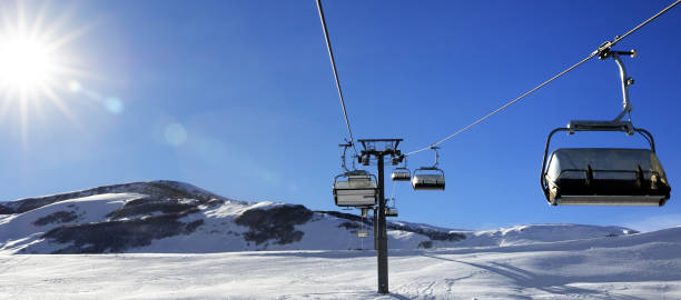 istock Chair-lift and blue sky with sun 1189176969