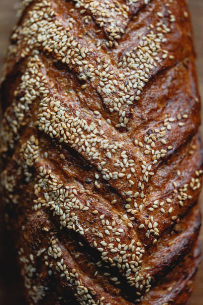 istock Close-up view of whole grain loaf bread crust with sesame. 1189178609