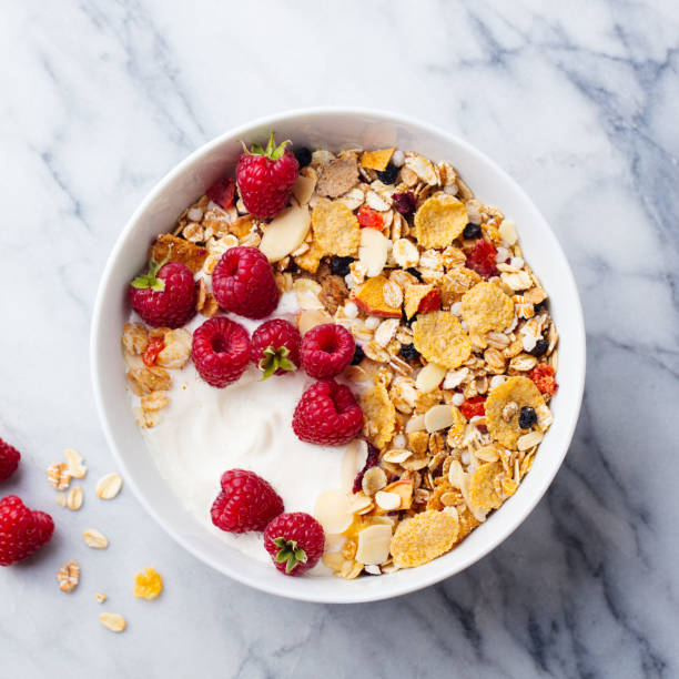 healthy breakfast. fresh granola, muesli with yogurt and berries. marble background. top view. - cereal breakfast granola healthy eating imagens e fotografias de stock