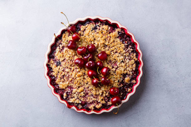 istock Cherry, red berry crumble in baking dish. Grey stone background. Top view. 1189180514