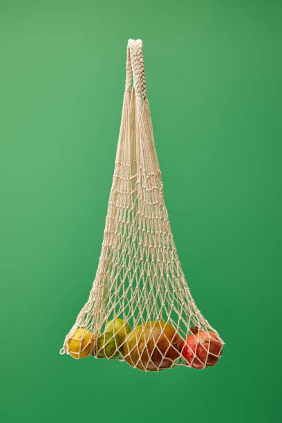 istock string bag with fruits isolated on green background 1189180789