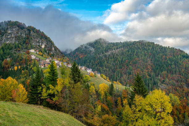 colourful aumtumn view across the cordevole valley with the villages of pecol and piaia in the background in belluno, italy - cordevole valley imagens e fotografias de stock