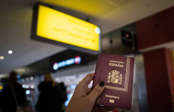 close up of woman holding a spanish passport at the airport - airport airport check in counter arrival departure board checkout counter imagens e fotografias de stock