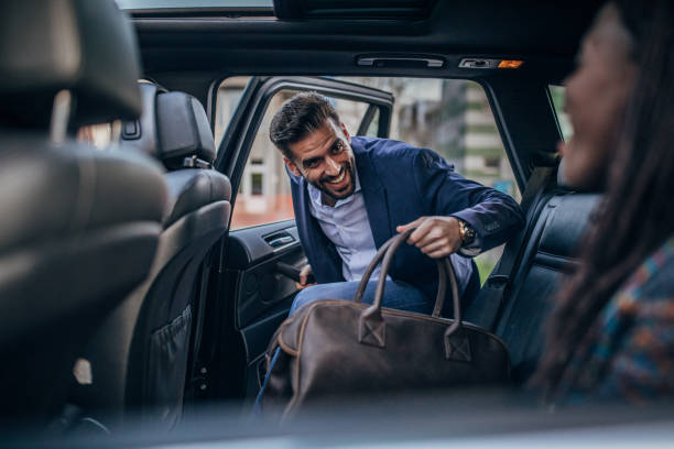 istock Smiling businessman entering a car 1189185053