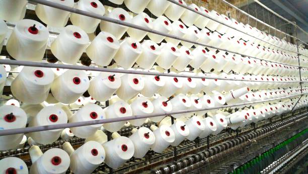 istock Textile industry - yarn spools on spinning machine in a textile factory 1189185173
