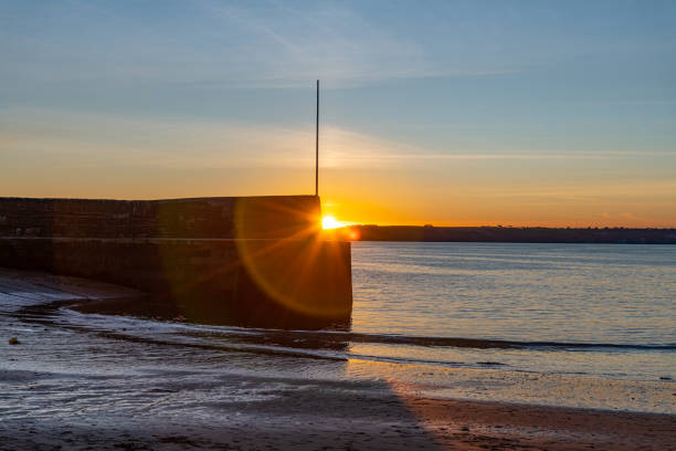 istock Sunflare at Polkerris harbour wall, Cornwall, in autumn 1189186706