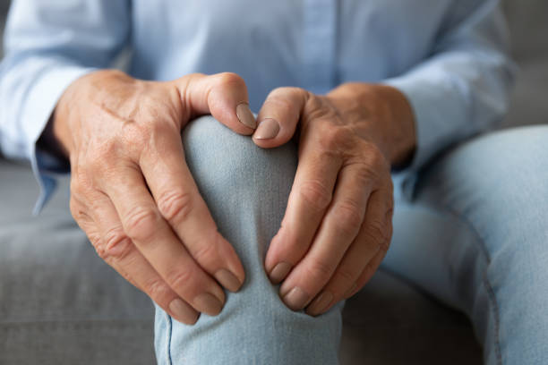 old woman touching knee feeling pain suffering from osteoarthritis, closeup - grandmother action senior adult grandparent imagens e fotografias de stock