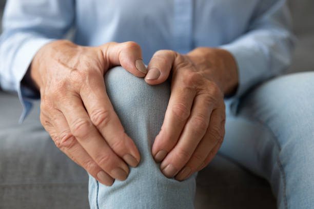 a mulher idosa que toca a dor do sentimento do joelho que sofre da osteoartrite, closeup - grandmother women one person senior adult - fotografias e filmes do acervo