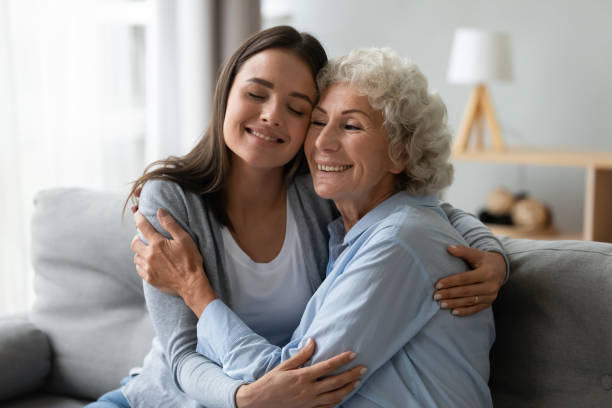 istock Affectionate young granddaughter and elderly grandma cuddling bonding at home 1189188529