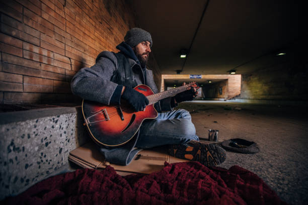 istock Homeless man playing guitar 1189188727