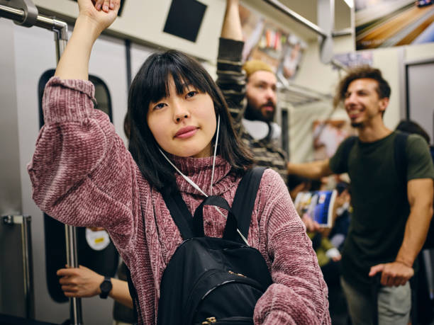 istock Young Woman on a Crowded Japanese Subway Train 1189189362