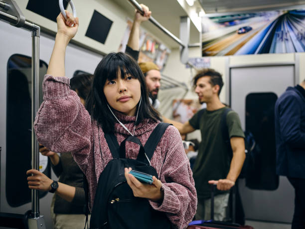 istock Young Woman on a Crowded Japanese Subway Train 1189189656