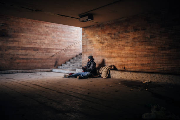 istock Homeless man playing guitar  in underpass tunnel 1189189730