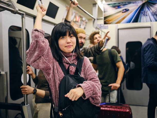 istock Young Woman on a Crowded Japanese Subway Train 1189189850