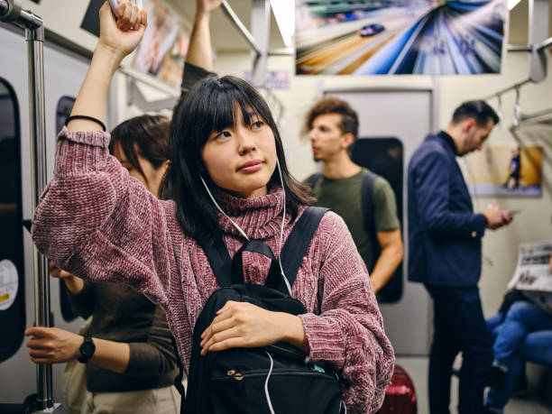 istock Young Woman on a Crowded Japanese Subway Train 1189189851