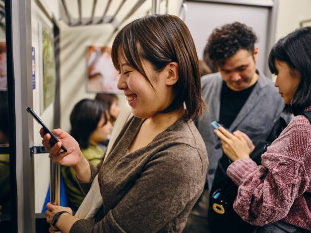 crowded japanese subway train - rush hour commuter on the phone tokyo prefecture imagens e fotografias de stock