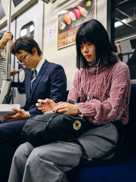 istock Young Woman on a Crowded Japanese Subway Train 1189190094
