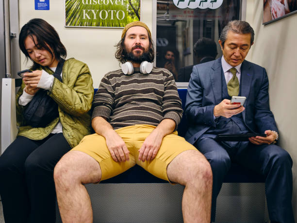 A Man Taking Up Space on a Crowded Japanese Subway Train A man spreading out and taking up too much space amongst a crowd of people on a Japanese subway train. Fully property released location. subway platform photos stock pictures, royalty-free photos & images