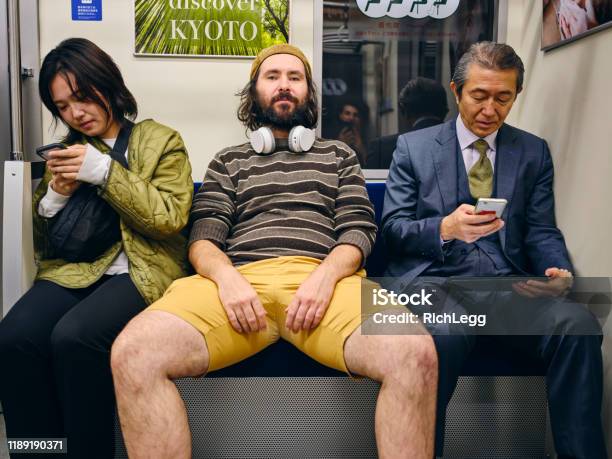 A Man Taking Up Space On A Crowded Japanese Subway Train Stock Photo - Download Image Now