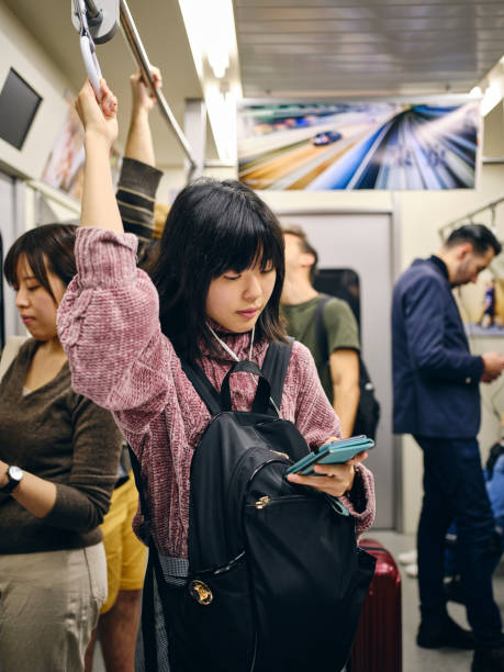 istock Young Woman on a Crowded Japanese Subway Train 1189190372