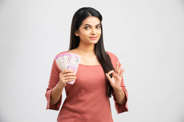 Young woman holding rupee notes Young woman holding rupee notes-Money savings concept rupee coin stock pictures, royalty-free photos & images