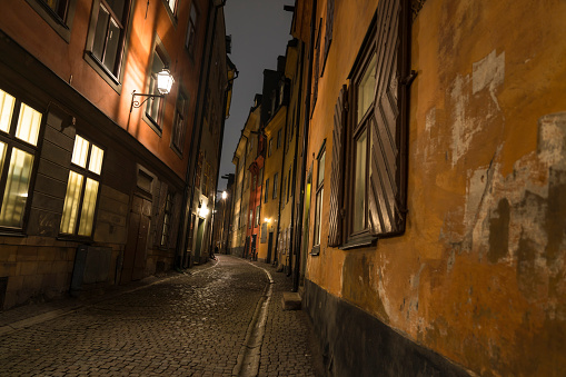 Low angle view on narrow street in old town, Gamla Stan at night, Stockholm.