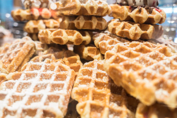 Close up of bunch of waffles covered with sugar.