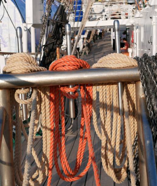 les cordes blanches, oranges et noires sèchent sur un support métallique spécial sur un voilier. le gréement d'un voilier. - cable winch sailing yacht sport photos et images de collection