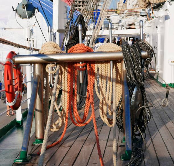 les cordes blanches, oranges et noires sèchent sur un support métallique spécial sur un voilier. le gréement d'un voilier. - cable winch sailing yacht sport photos et images de collection