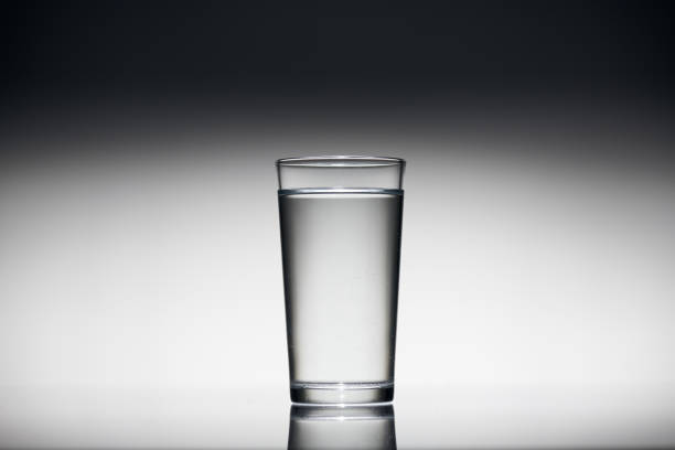 istock one glass of water on a dark background 1189197796