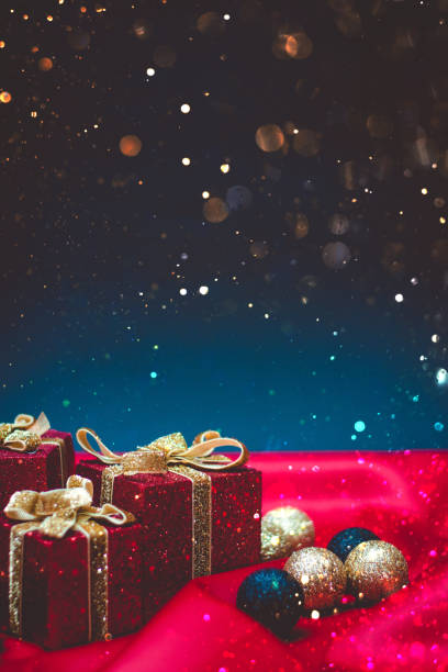 istock Sparkly red present boxes with Christmas lights on a red and blue background with bokeh 1189202224