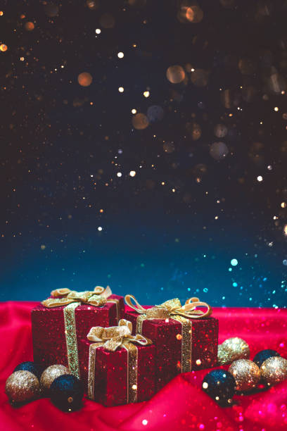istock Sparkly red present boxes with Christmas lights on a red and blue background with bokeh 1189202238