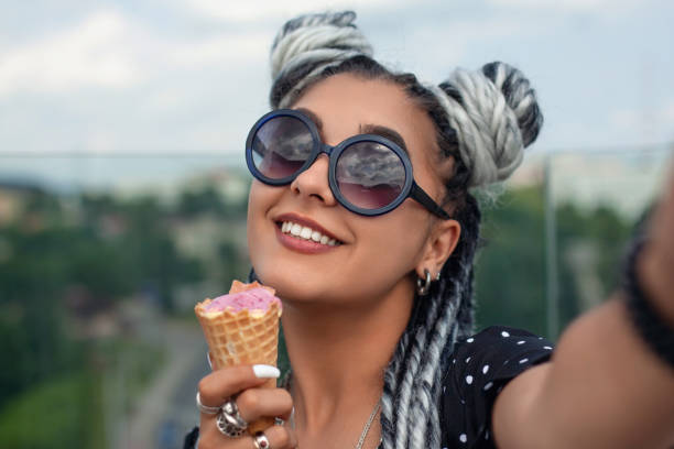 Beautiful young woman with white dreadlocks eating ice cream and taking selfie. Summer time. Beautiful young woman with white dreadlocks eating ice cream and taking selfie. Summer time. selfie photos stock pictures, royalty-free photos & images