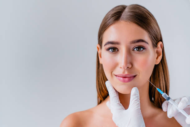 la donna affronta cosmetologia o chirurgia plastica e concetto di bellezza sullo sfondo - plastic beauty injecting protective glove foto e immagini stock