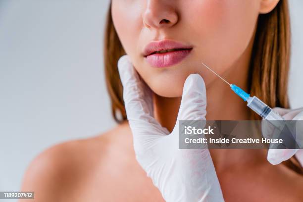 Close Up Of Beautiful Woman Getiing Injection In Her Lips On Background Stock Photo - Download Image Now