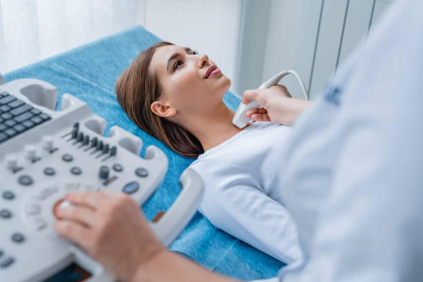 Woman getting her neck examined by female doctor using ultrasound scanner at modern clinic Medicine, Hospital, Medical Clinic, Ultrasound, Doctor chaise longue photos stock pictures, royalty-free photos & images