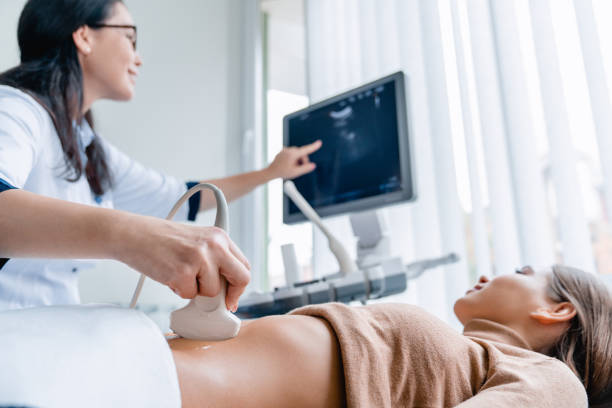 초음파 스캐너를 사용하는 중간 성인 여성 의사 - human pregnancy ultrasound medical exam doctor 뉴스 사진 이미지