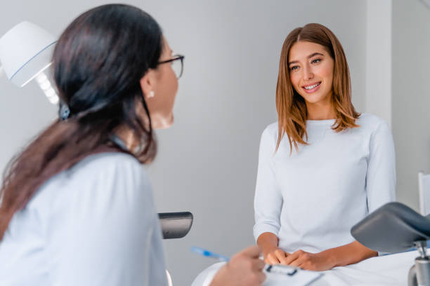 ginecólogo hablando con una joven paciente durante la consulta médica en la clínica moderna - patient information fotografías e imágenes de stock