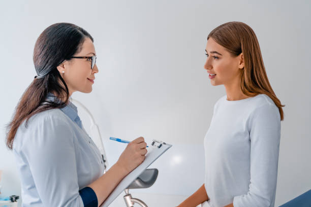 female adult gynecologist working with patient in clinic - contraceção imagens e fotografias de stock