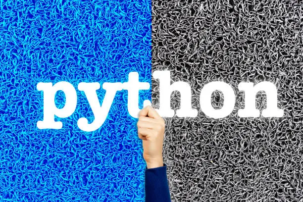 Photo of Python programming language concept. Woman developer with her hand holding modern sign with word python, on wire background.