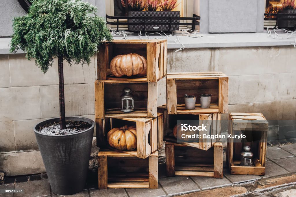 happy halloween. rustic decoration with pumpkins and lanterns in wooden boxes for halloween celebration in european city street. creative arrangement. fall holidays Porch Stock Photo