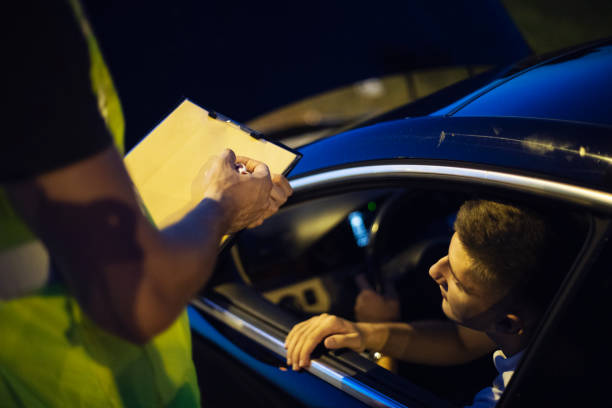 Young Man in Trouble on the Road One young person pulled over, looking at the police officer, getting a ticket traffic fine stock pictures, royalty-free photos & images