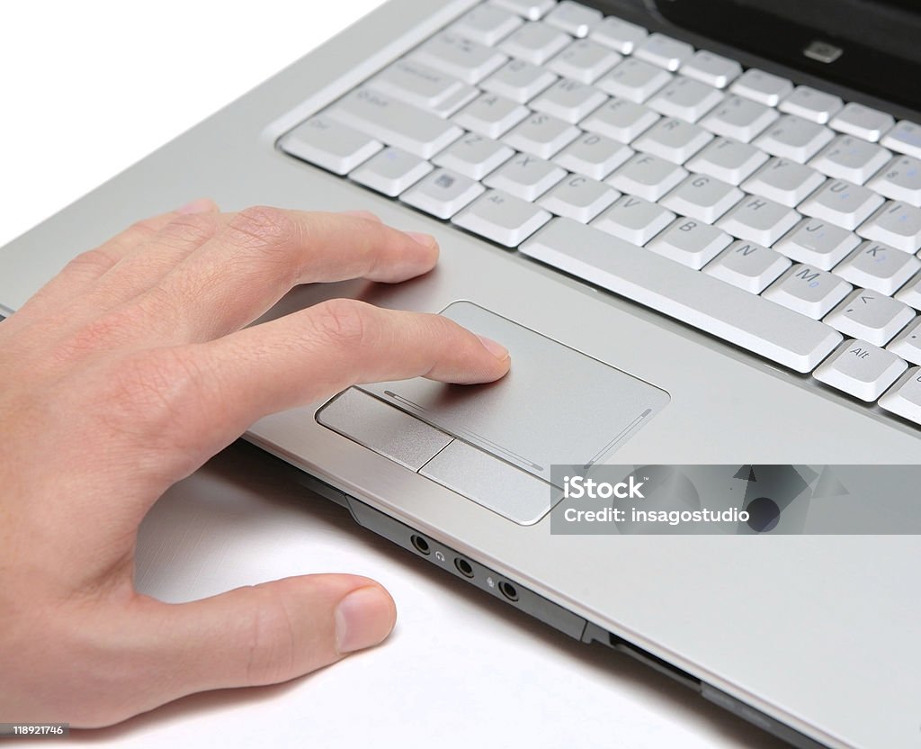 Mano trabajando en una computadora portátil en la unidad de entrada - Foto de stock de Blanco - Color libre de derechos