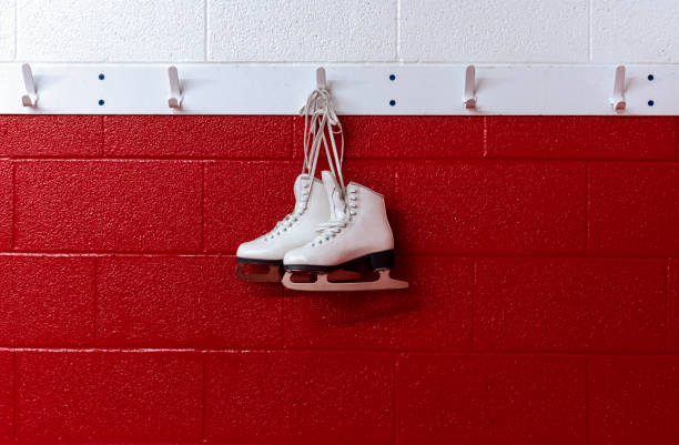 istock Figure skates hanging in locker room over red background with copy space 1189220657